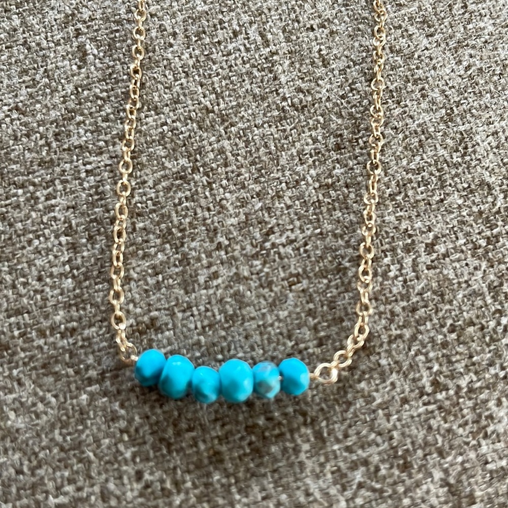 Gold necklace w/ turquoise beads.